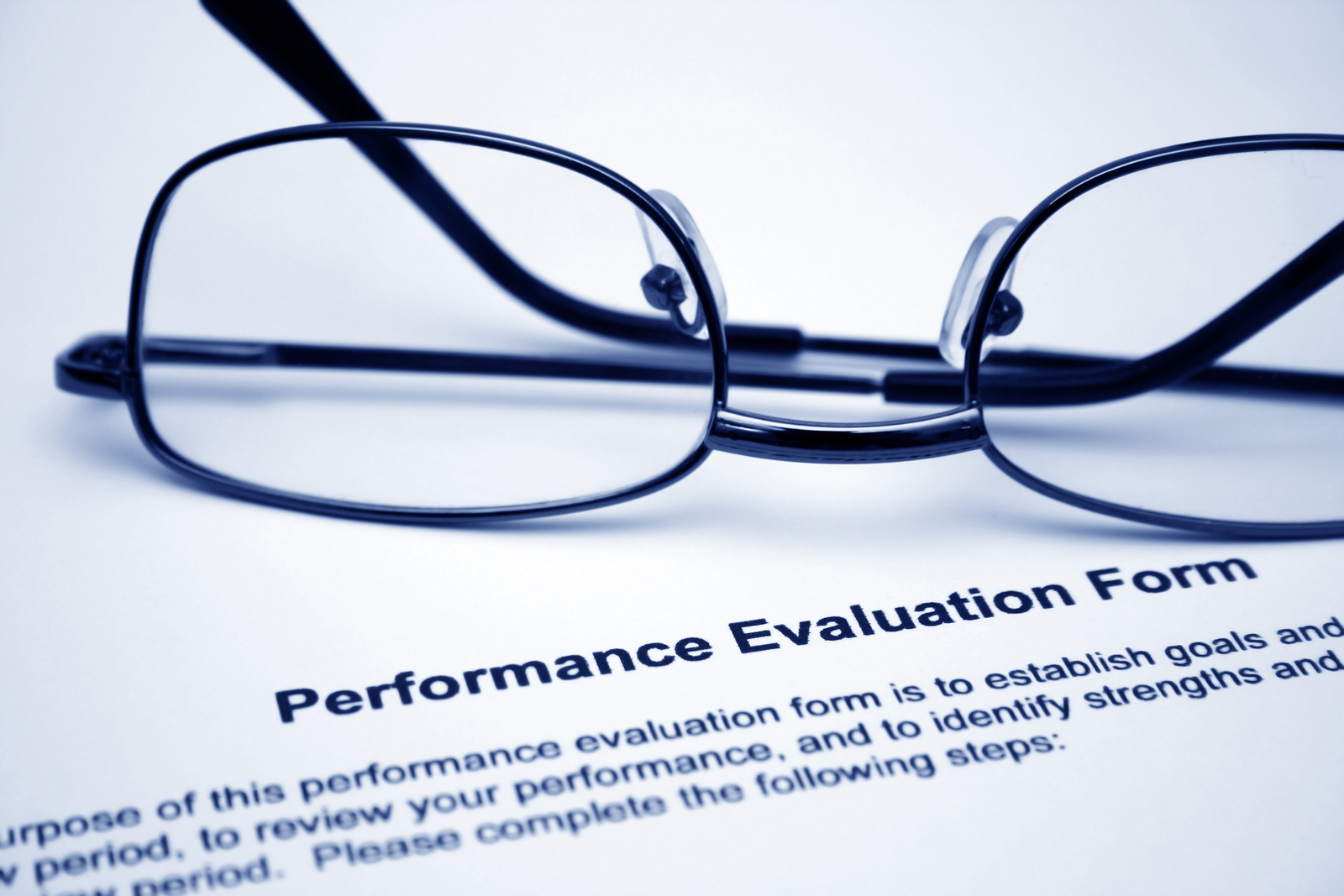 Performance Management - Close up of glasses on performance evaluation form